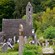 An old brick tower looms in the background of a cemetery with weathered headstones